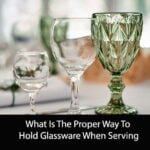 What Is The Proper Way To Hold Glassware When Serving